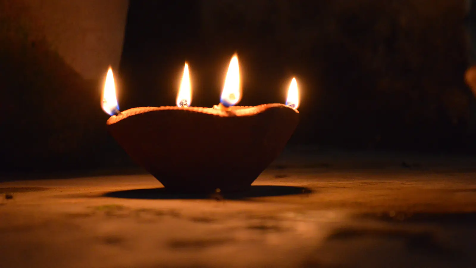 A single clay lamp with five flames glowing in the dark