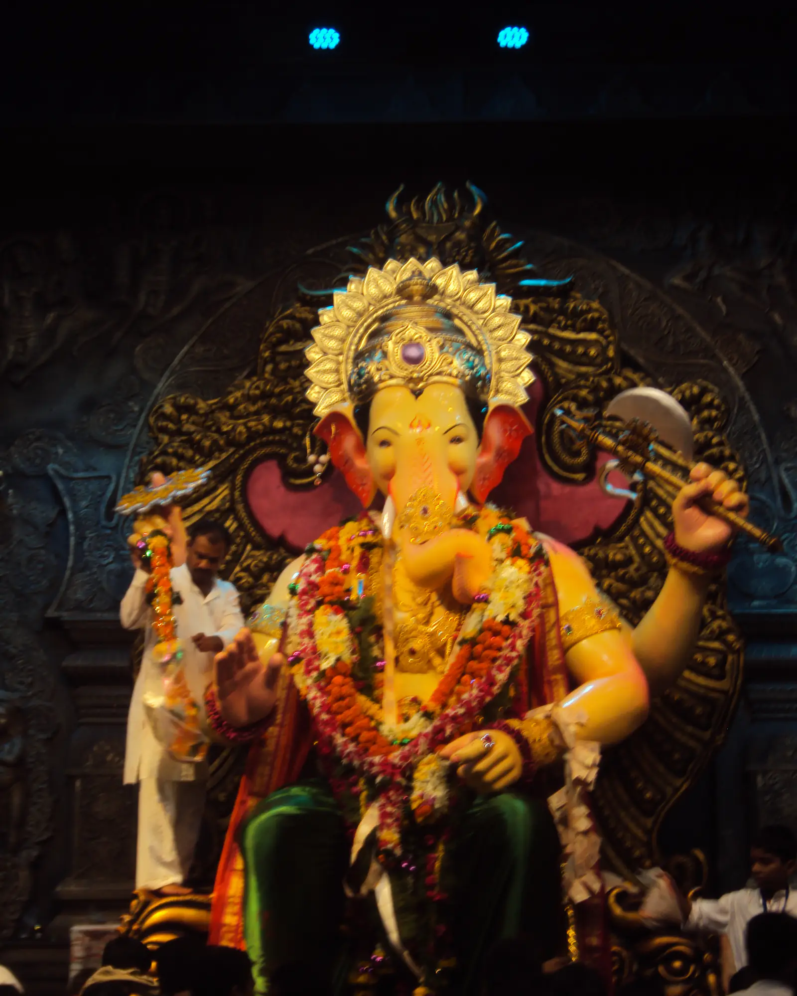 A towering golden Ganesha idol seated under a canopy, garlanded, during the Ganesh festival in Mumbai