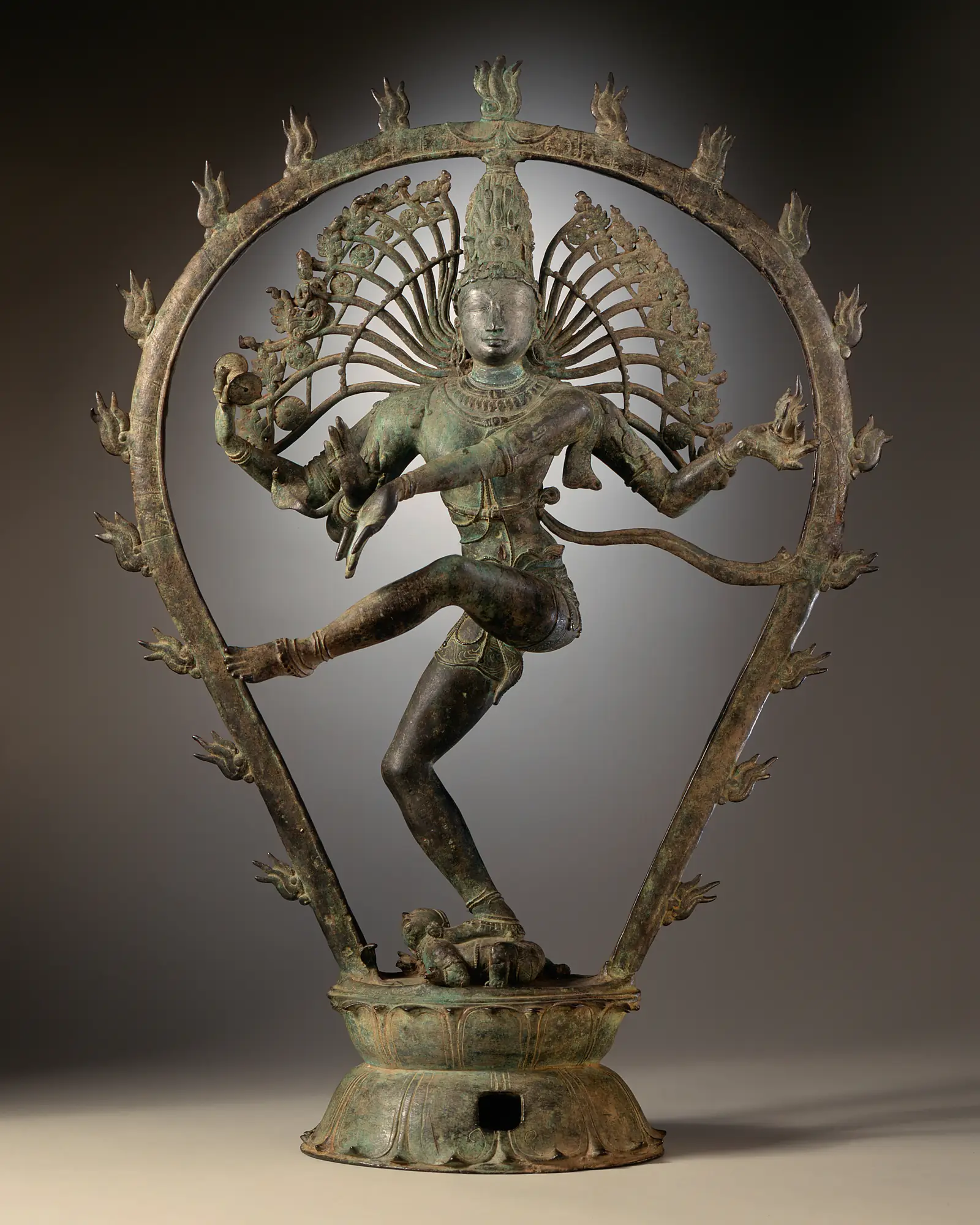 A Chola bronze of Shiva dancing inside a ring of flames, one foot raised, on the dwarf of forgetfulness