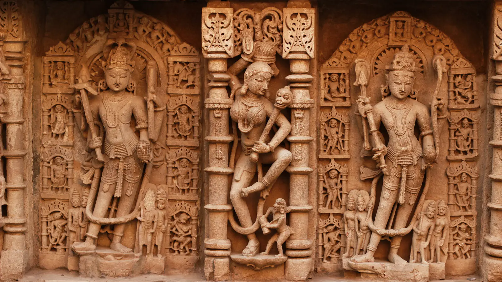 Carved sandstone figures of gods and attendants in niches of the Rani ki Vav stepwell